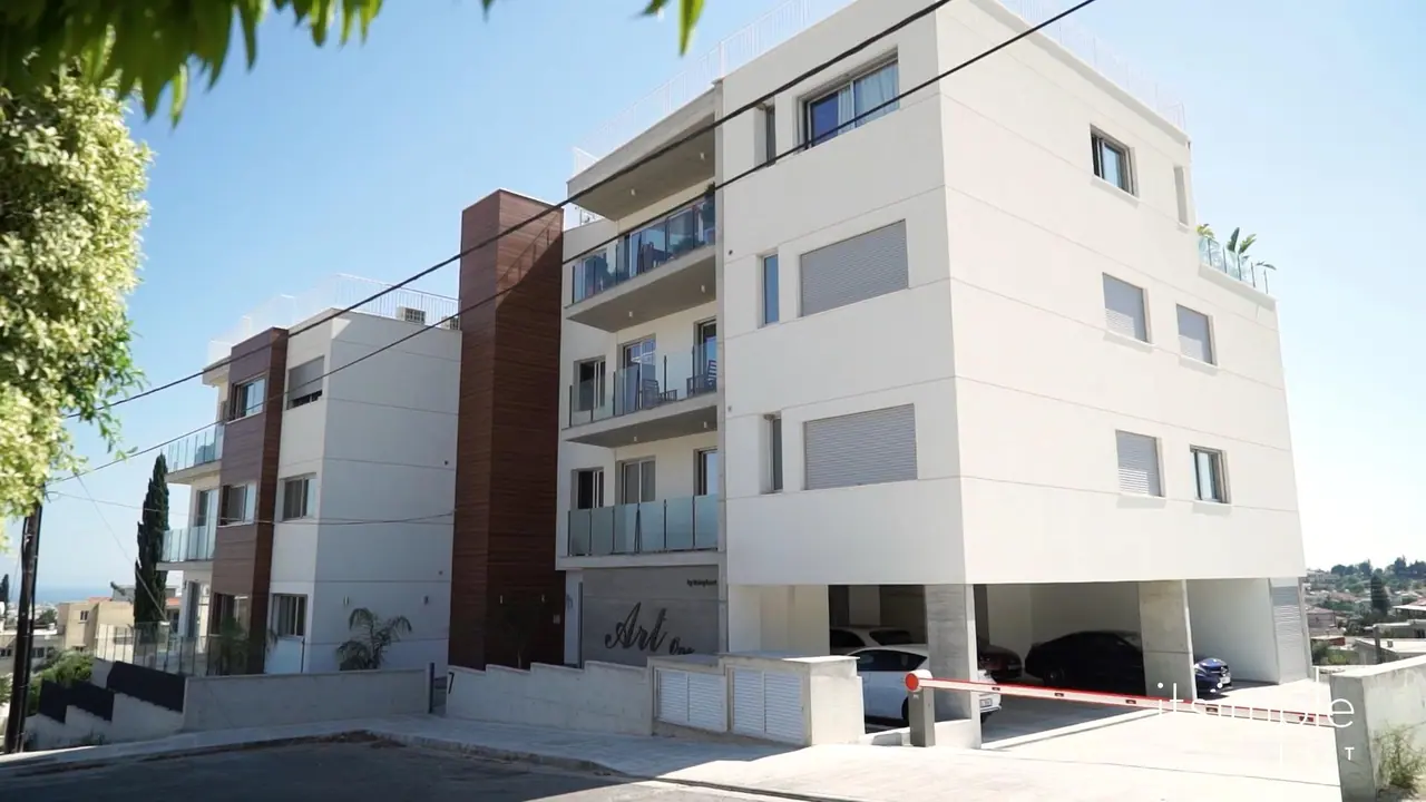 Μια σύγχρονη λευκή πολυκατοικία κάτω από καταγάλανο ουρανό